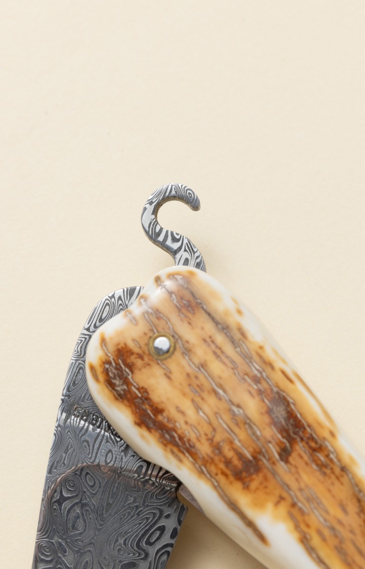 Photo du manche de Bixia, couteau basque en ivoire de mammouth et lame damas et crochet servant à l'ouverture