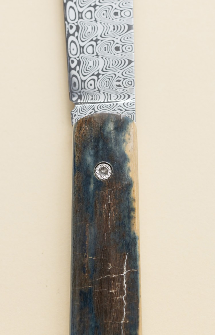 Photo de L'Alios, couteau à cran d'arrêt en ivoire de mammouth bleu et lame damas fermée, plan rapproché