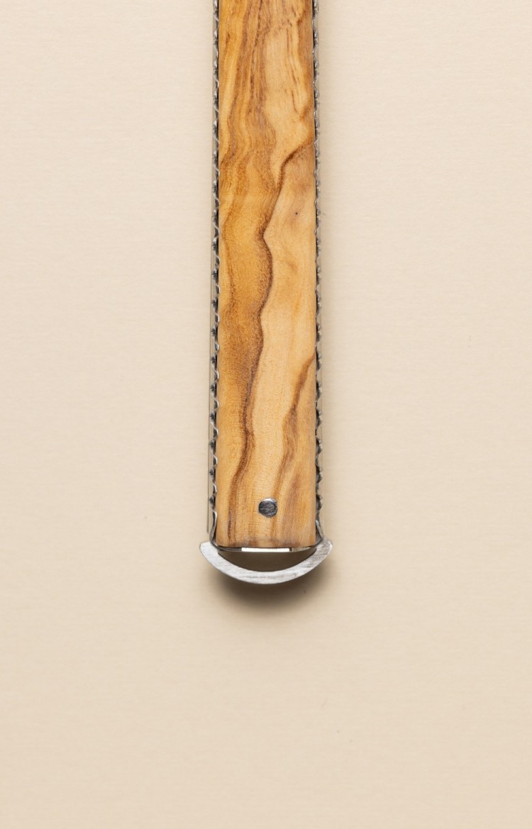 Photo de l'extrémité du ressort du couteau  basque Artzaina en olivier, rappelle la forme arrondie du pommeau du Makila