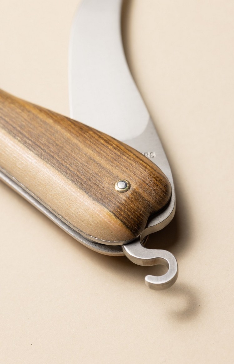Photo de Bixia couteau artisanal basque en forme de piment d'Espelette en pistachier, lame entrouverte, plan rapproché