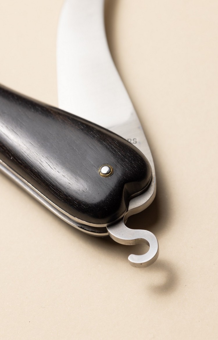 Photo de Bixia couteau artisanal basque en forme de piment d'Espelette en ébène, lame entrouverte, plan rapproché