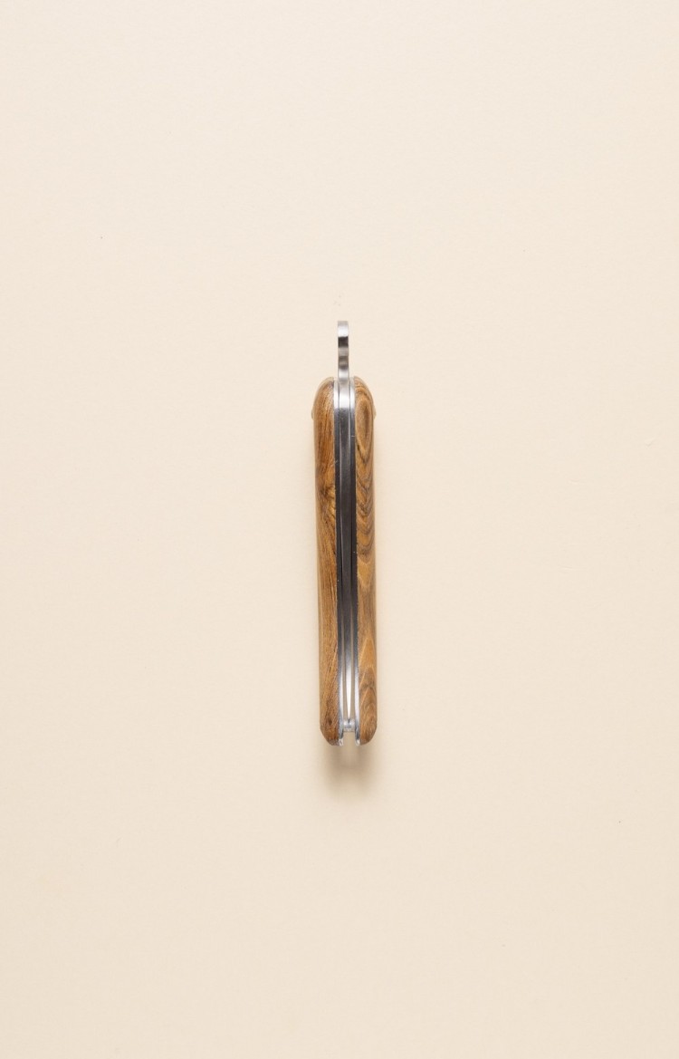 Photo de Bixia couteau basque, forme de piment d'Espelette en genévrier, lame fermée, posé sur le dos du couteau, vue sur lame