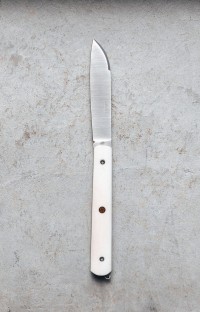 Photo du couteau artisanal l'Alios en os de vache, lame ouverte, rivet mosaïque rouge Photo du couteau artisanal l'Alios en os de vache, lame ouverte, rivet mosaïque rouge