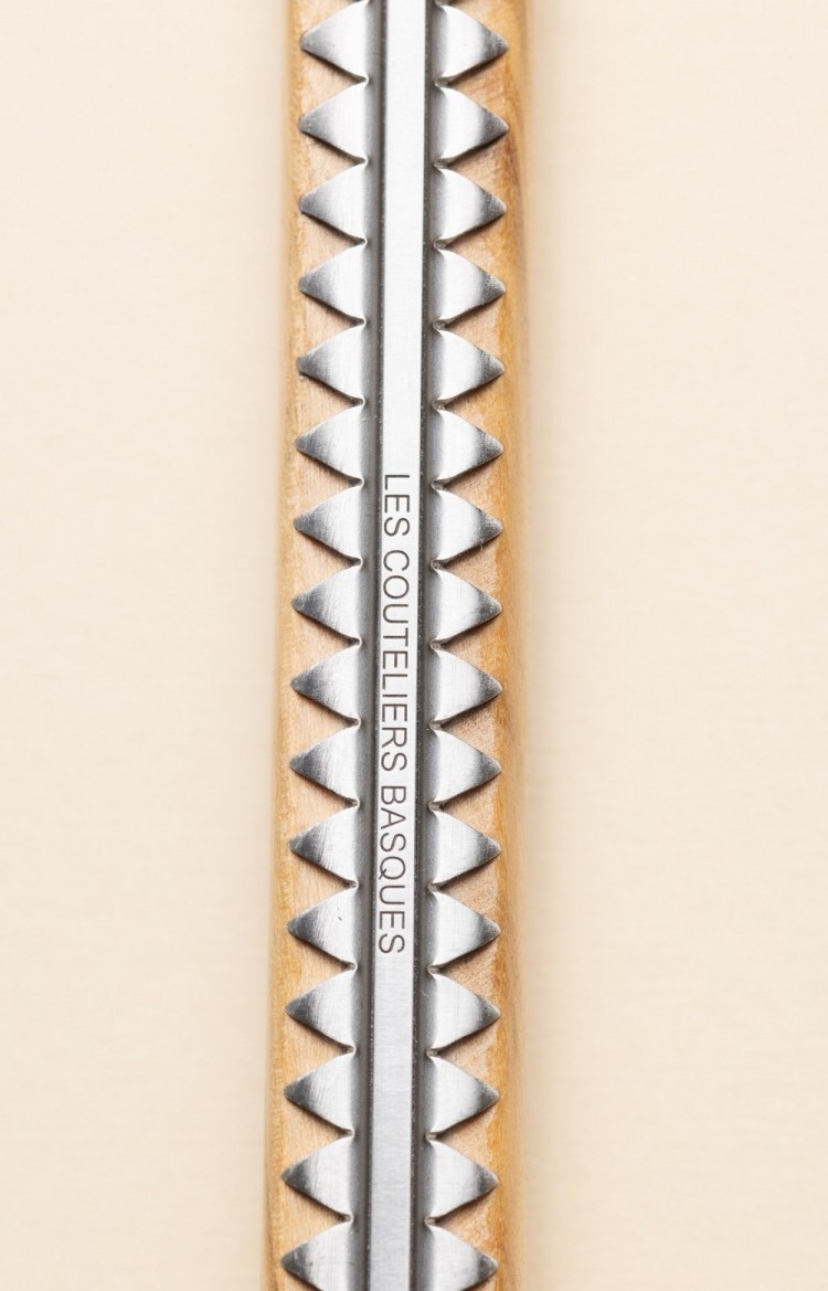 Photo rapprochée du dos de Artzaina, couteau de table en olivier, platines ciselées et arrondi du pommeau du makila