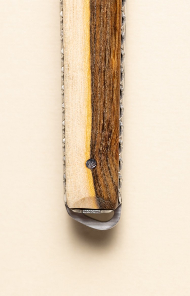 Photo rapprochée de l'extrémité de Taldea, couteau de table en pistachier, platines ciselées