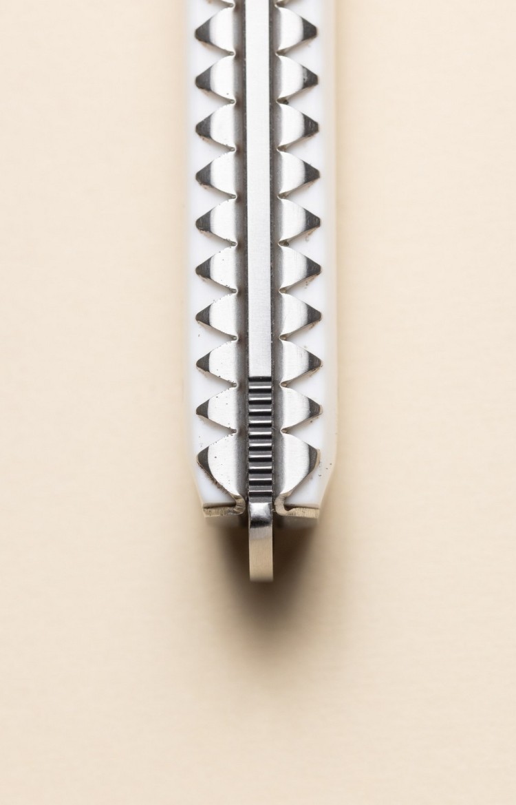 Photo rapprochée du dos de Artzaina, couteau de table en acrylique, platines ciselées et arrondi du pommeau du makila