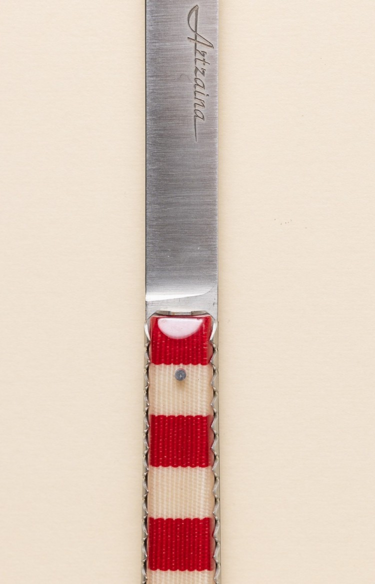 Photo de Artzaina, couteau artisanal en linge basque rouge avec alternance de bandes blanches et rouges, plan rapproché