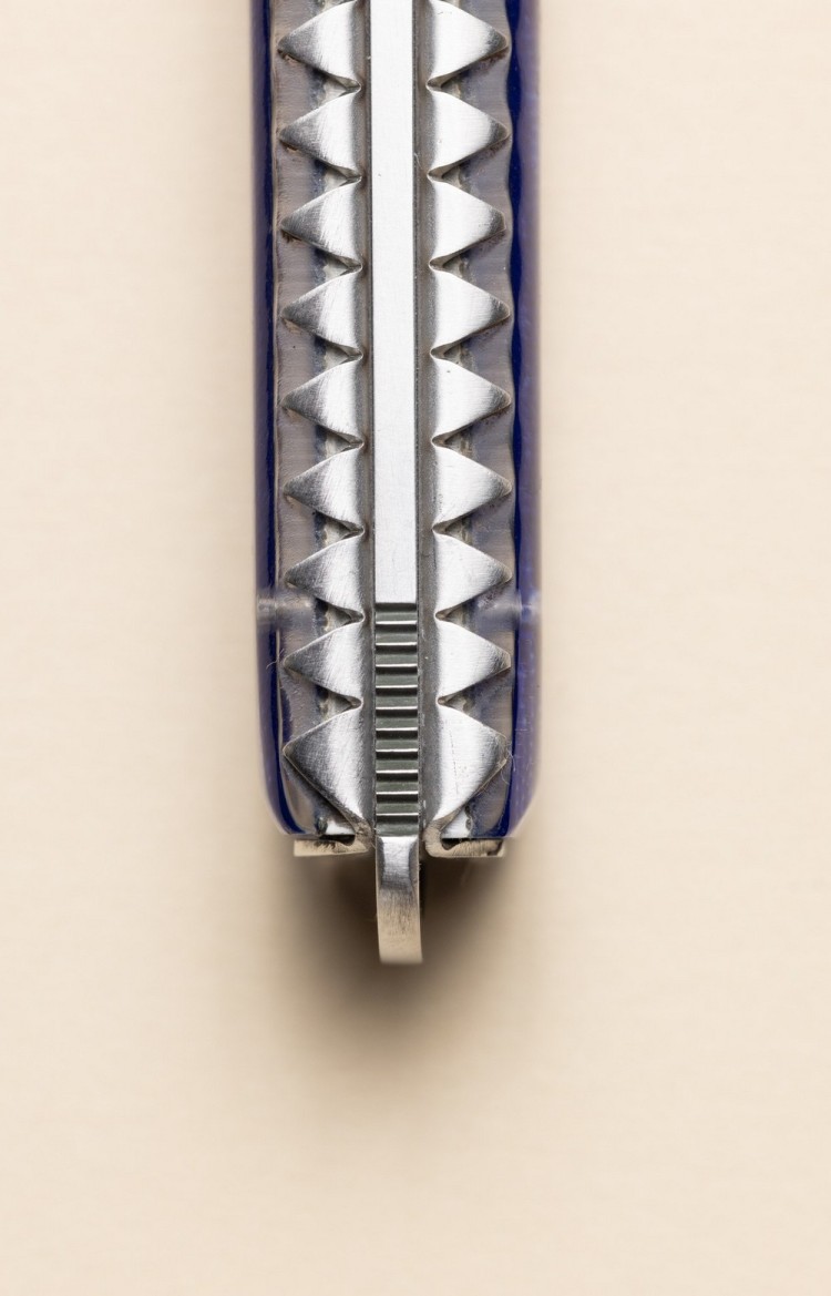 Photo rapprochée du dos de Artzaina, couteau de table en linge basque bleu, platines ciselées et arrondi du pommeau du makila