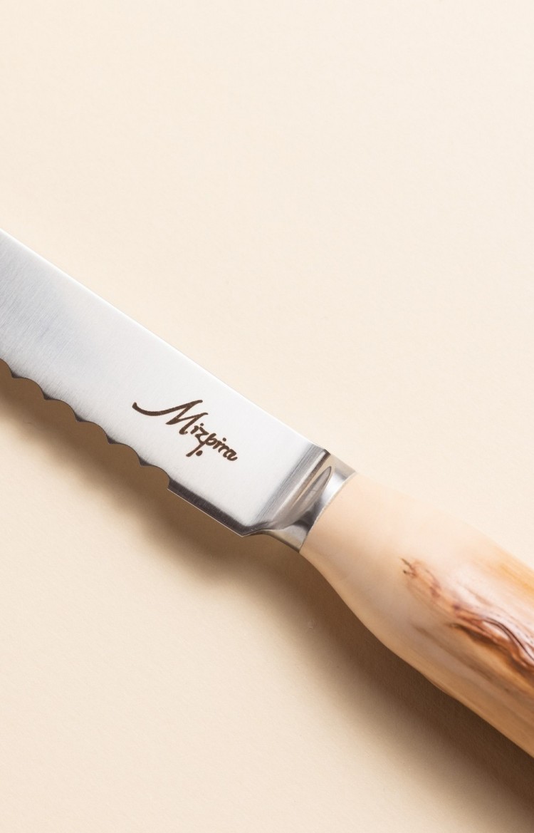 Photo rapprochée de Mizpira, couteau artisanal à pain en néflier scarifié